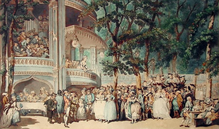 A crowd of revellers drink and carouse amongst the grandly illuminated trees and temporary structures of Vauxhall Pleasure Gardens, circa 1786.