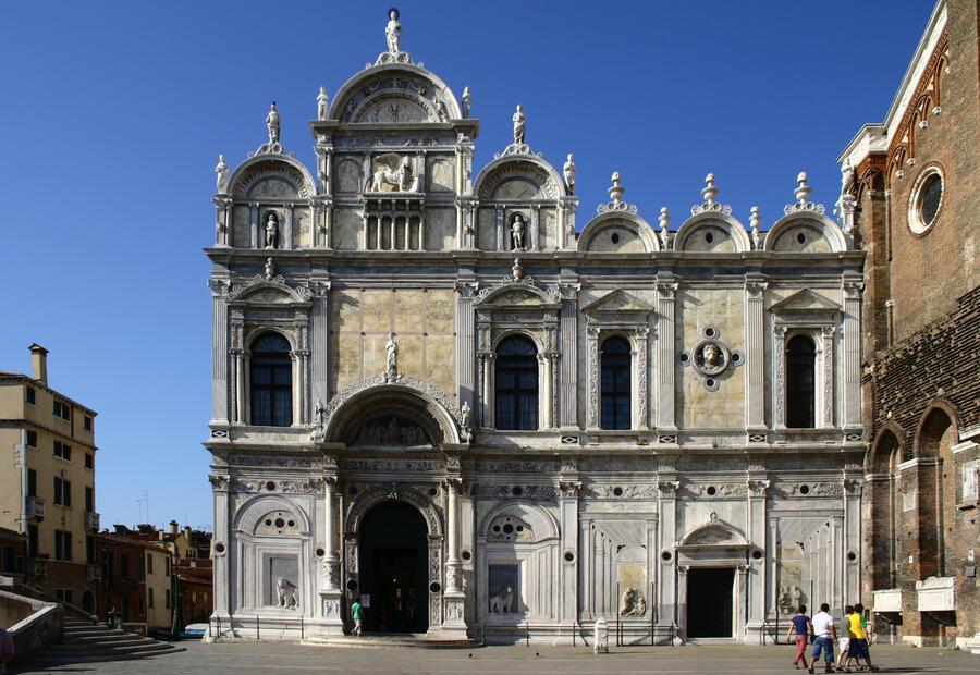 The Façade of Scuola Grande di San Marco, a white marble church in Venice.