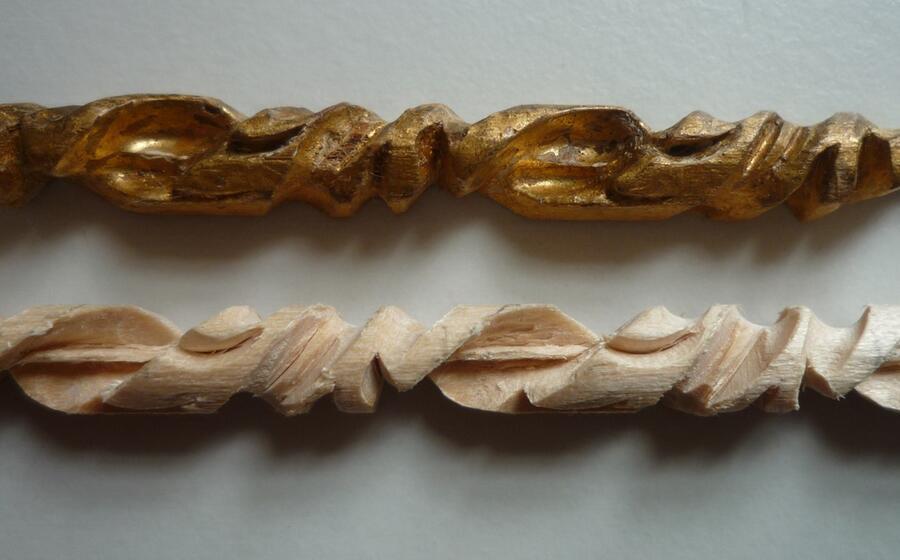 The original carved pin alongside a newly carved replica of the same pin.