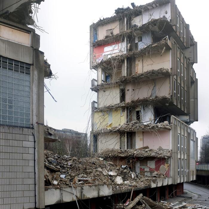 Halfway through the demolition of a 1960s block of housing, with the interior rooms exposed.