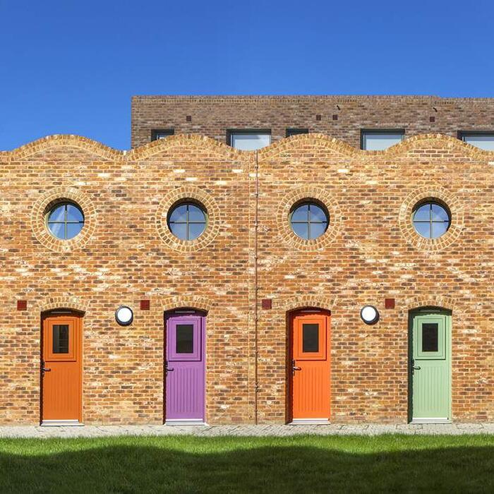 Colourful doorways, each with a porthole window above.