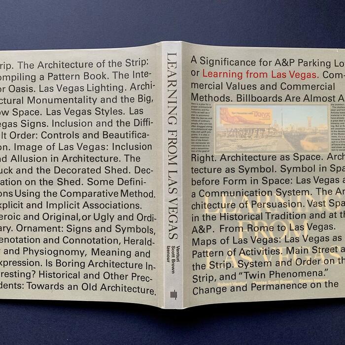 The book Learning from Las Vegas placed opened and face down on a surface so as to show its cover, which is covered with text.