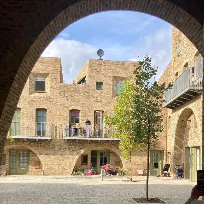 A resident stands on their balcony of one of the houses of the McGrath Road development.