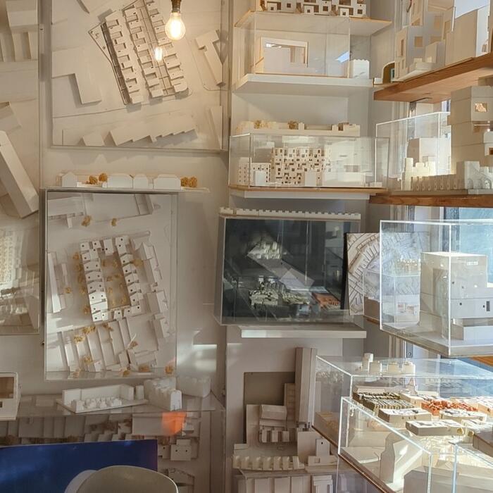 A bright room full of architectural models on shelves and affixed to the walls.