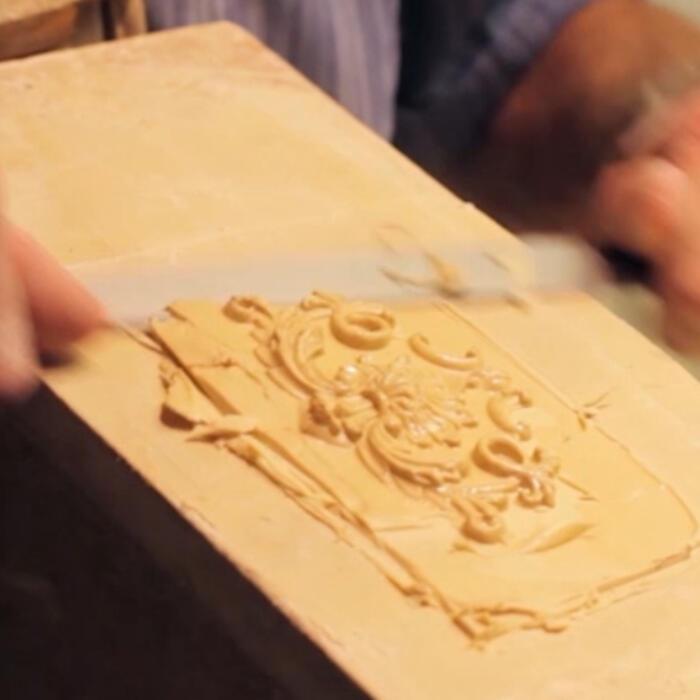 A person using a blade to cut out the finished mould