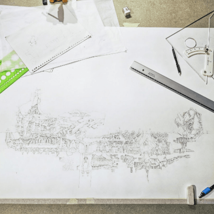 A drawing surrounded by sketches, pencils, rulers