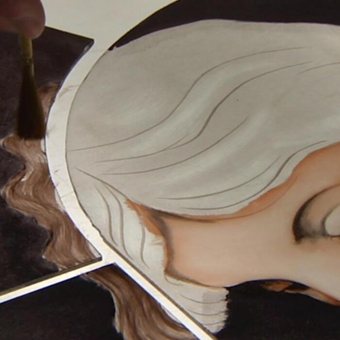 A brush painting hair on the painted glass window