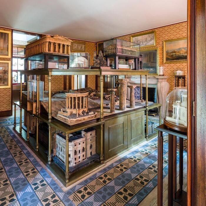 A photo of the Model Room in the Soane Museum which is a smallish room with a central stand containing numerous architectural models on three shelves. It stands about 6 feet high.