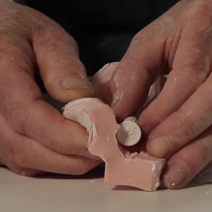 Hands taking a cast model column from a silicon mould
