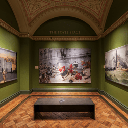 A room with green walls, and 3 pictures on the wall