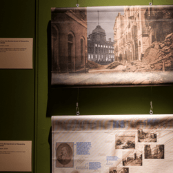 A green wall with two collages hanging against it.