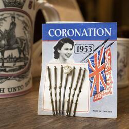 A packet of coronation hairpins from 1953, with a photo of the young Elizabeth and union jack emblemn.