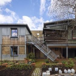 The courtyard garden of 9/10 Stock Orchard Street, showing an open staircase running up to a first floor level.