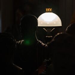 A bust, positioned in front of a lamp.