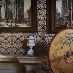 Eliza's mantelpiece, complete with artworks, a clock and a fire shield.