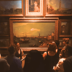 A VA talking to guests about the large Canaletto in the Picture Room.