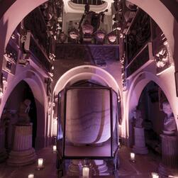 The Sepulchral Chamber of the Museum, focused around the sarcophagus of Seti I, illuminated for an evening event.