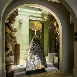 In the Crypt of the Museum, an abstract figure sculpture is positioned between two casts of Venus.