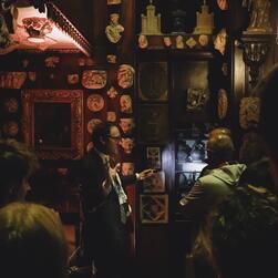 A member of the Museum team uses a torch to illuminate details of the Monk's Parlour for visitors.