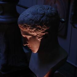 A bust illuminated from below by an uplighter in the Museum's Dome area.