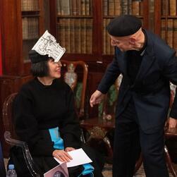 Stephen checks the fitting of Alice's headwear.
