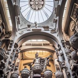 Looking up from the basement of Sir John Soane's Museum towards the twin skylights of its roof. The cast of Apollo stands above, with the walls decorated in eclectic architectural casts and antiquities.