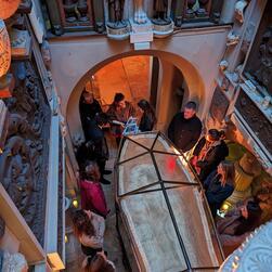 A view into the Sepulchral Chamber of the Museum from above, showing visitors gathering about the Sarcophagus of Seti I.