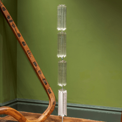 A tall cylindrical glass sculpture sits in the middle of the display.