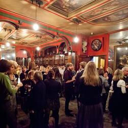 Photograph of a drinks reception in full swing in the Library-Dining Room of Sir John Soane's Museum