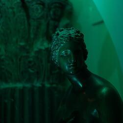 A cast of the Medici Venus in the Museum's crypt, illuminated with green light.