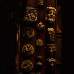 Casts of gargoyles and grotesques on the dark walls of the Monk's Parlour.